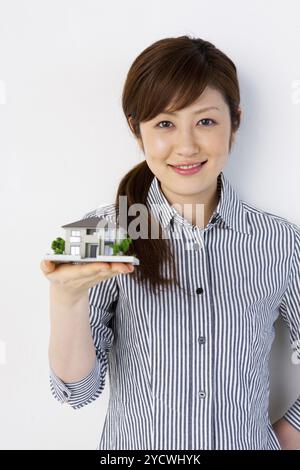 Donna che tiene una modella di casa che tiene una modella di casa Foto Stock