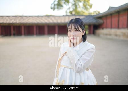 Una coppia coreana, un uomo di 30 anni e una donna di 20 anni, cammina armoniosamente attraverso un edificio storico a Seoul, Corea del Sud, indossando Hanbok. Foto Stock