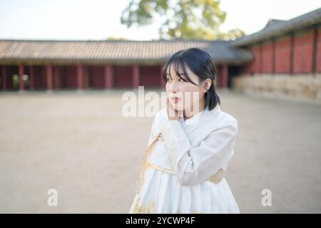 Una coppia coreana, un uomo di 30 anni e una donna di 20 anni, cammina armoniosamente attraverso un edificio storico a Seoul, Corea del Sud, indossando Hanbok. Foto Stock