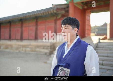 Una coppia coreana, un uomo di 30 anni e una donna di 20 anni, cammina armoniosamente attraverso un edificio storico a Seoul, Corea del Sud, indossando Hanbok. Foto Stock