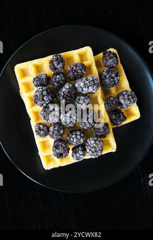 Cialde belghe con congelati more su sfondo nero Foto Stock
