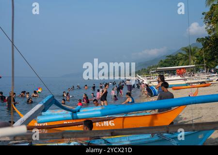 Laiya Beach, sabato 17 agosto 2024: Le persone amano nuotare anche nella stagione dei monsoni. Provincia di Batangas, Filippine Foto Stock