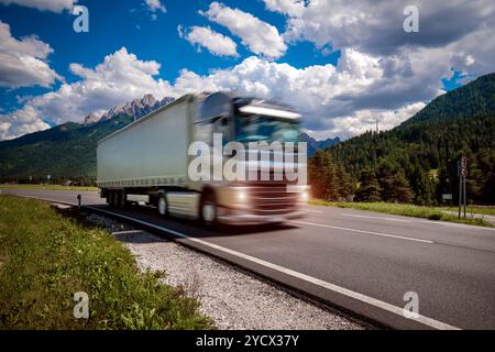 Carrello carburante precipita l'autostrada sullo sfondo delle Alpi. Carrello Car in motion blur. Foto Stock