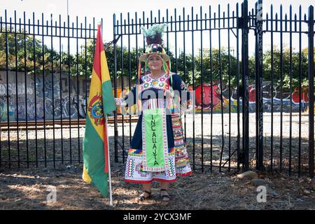 Un membro boliviano dei ballerini folcloristici Incallajta che detengono la bandiera boliviana prima della parata boliviana a Jackson Heights, Queens, New York. Foto Stock