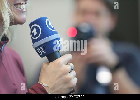 Norimberga, Germania. 24 ottobre 2024. Vestizione degli atleti della DSV (Associazione tedesca di sci) nel MesseCongressCentrum. Un atleta tiene in mano un microfono di ARD e BR (Bayerischer Rundfunk). Crediti: Daniel Löb/dpa/Alamy Live News Foto Stock