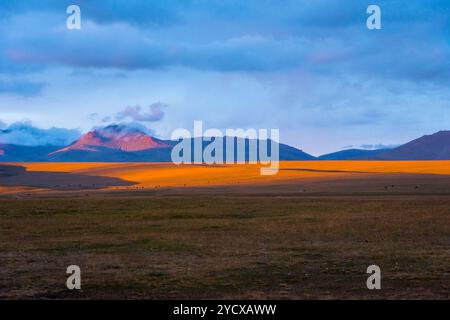 Montagne intorno al lago Song Kul in un sole all'alba, Kirghizistan Foto Stock