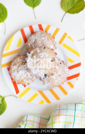 Cupcake colorati su un piatto con foglie verdi e asciugamano Foto Stock