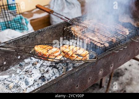 Appetitosi pezzi di grigliate di pesce e carne cucinate alla griglia sulla brace Foto Stock