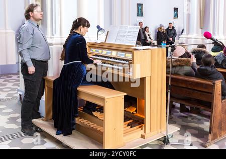 Donna che suona sull'organo elettronico della parrocchia cattolica romana Foto Stock