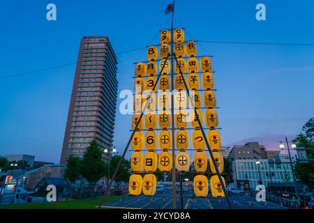 Akita, Giappone - 5 agosto 2024: Una struttura a lanterna torreggiante illumina il cielo notturno durante l'Akita Kanto Festival. Le lanterne sono decorate con h Foto Stock