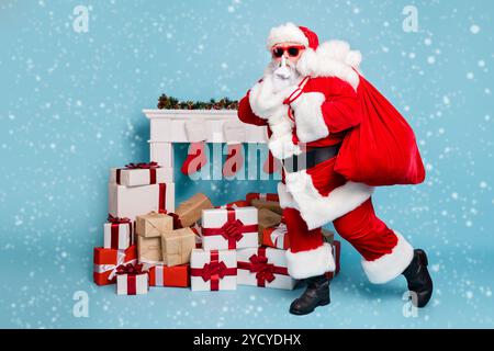 Per tutta la lunghezza del corpo vista la dimensione del suo egli nice fat misterioso barbuto Santa portando offrendo grande sacco grande pila pila acquisti che mostra segni di shh Foto Stock
