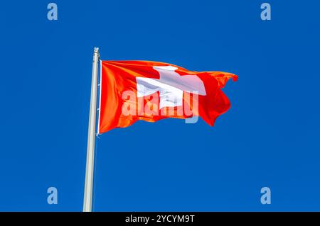 Bandiera della Svizzera che sventola nel vento contro il cielo Foto Stock