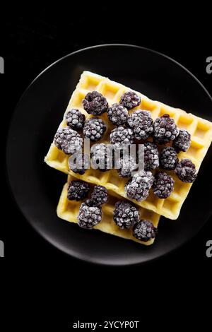 Cialde belghe con congelati more su uno sfondo nero, close-up Foto Stock