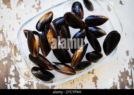 Cozze fresche su un vecchio legno tavolo bianco. Foto Stock