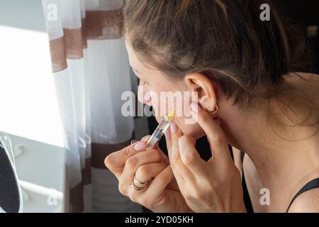 Donna che esegue mesoterapia, procedura di rivitalizzazione biologica, iniettando medicina nel collo e nel viso Foto Stock