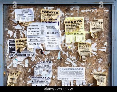 Samara, Russia - 29 Aprile 2018: Live bulletin board. Annunci di carta sulla parete. Filamenti di vari annunci su una vecchia parete in legno Foto Stock