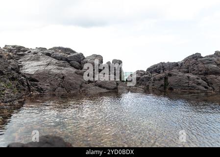 Enormi rocce scure e scivolose contro il cielo nuvoloso. Natura incontaminata. Salvador, Brasile Foto Stock