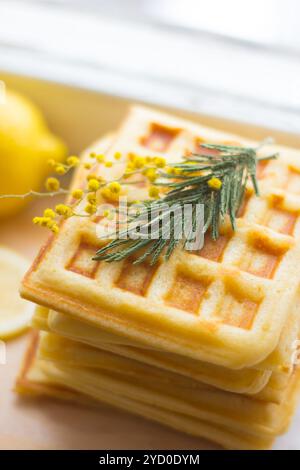 Cialde viennesi piene e limone a fette. Affettare il limone su una tavola di legno. La frutta viene tritata. Limone acido. Foto Stock