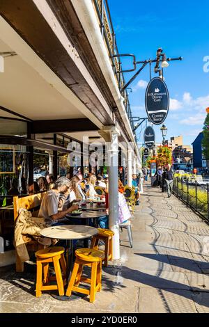 Persone che cenano all'aperto presso ristoranti e caffetterie a St Katharine Docks, Londra, Inghilterra Foto Stock