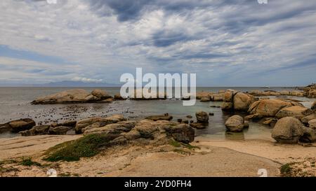 paesaggio di grandi massi di granito che creano piscine di roccia d'acqua poco profonde presso la spiaggia di boulder vicino a città del capo, accanto alla colonia di pinguini africani Foto Stock