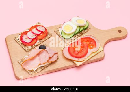 Diversi tipi di pane integrale con Prato, pomodoro, Rasth, cetriolo e formaggio. Colazione facile. Dieta alimentare. Panini veloci e sani. Croccante con gustoso ripieno. Snack dietetico sano Foto Stock