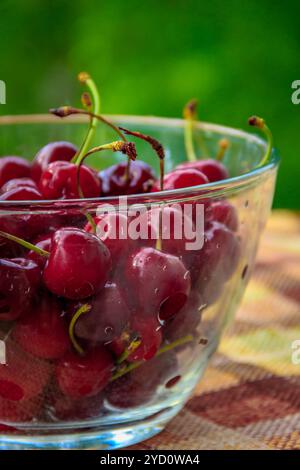 Ciotola con cherry. Vaso di vetro con frutti di bosco. Frutta estiva. Frutti dolci. La frutta rossa Foto Stock