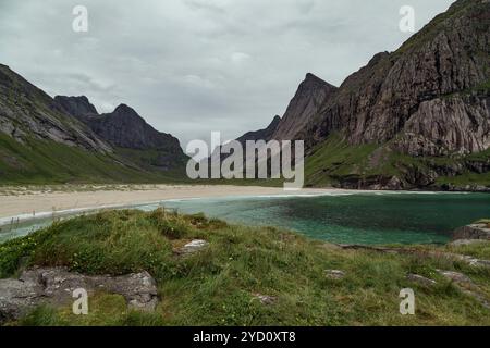 Esplora lo splendido lago glaciale e le spettacolari montagne di Bunes Beach nelle isole Lofoten, Norvegia, mentre gli escursionisti si divertono in un tranquillo trekking attraverso la natura incontaminata Foto Stock