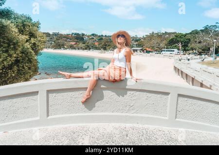 Donna che si rilassa sul ponte ad arco godendosi il sole estivo Foto Stock