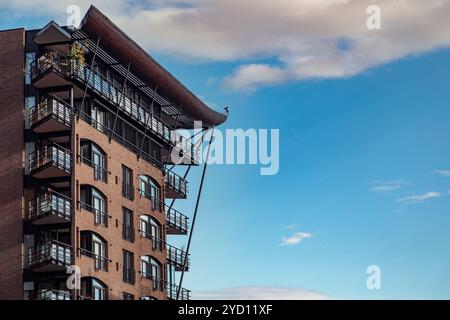 La suggestiva facciata di un complesso di appartamenti contemporaneo mostra la sua moderna ingegneria in un ambiente urbano. Le nuvole di Cumulus si spostano sopra l'ar di Oslo Foto Stock