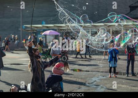 Oslo, Norvegia - 18 agosto 2018: L'artista di strada crea grandi bolle di sapone per i bambini sul lungomare del porto di Oslo Foto Stock
