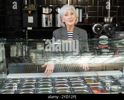 Un'anziana venditore sorridente che offre un rinfrescante tè boba taiwanese Foto Stock