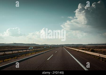 La strada asfaltata e vuota si spinge oltre l'orizzonte. Buona superficie stradale. Autostrada, autostrada per viaggiare in auto Autobahn su dessert e colline Foto Stock