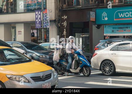Taipei, Taiwan - 10 ottobre 2019: Vita di strada frenetica a Taipei mentre un corriere si sposta attraverso il traffico cittadino Foto Stock