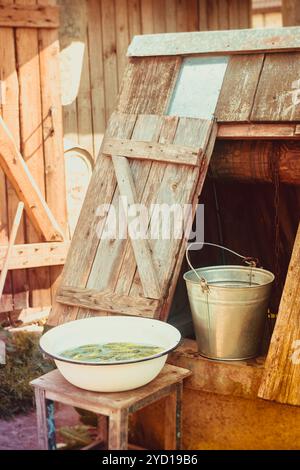 Stira secchio e pozzo. Acqua dal suolo. Foto Stock