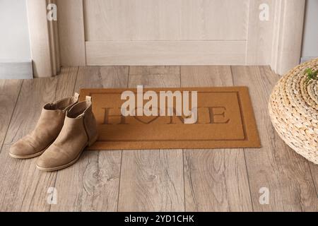 Tappetino con scarpe vicino alla porta nel corridoio Foto Stock