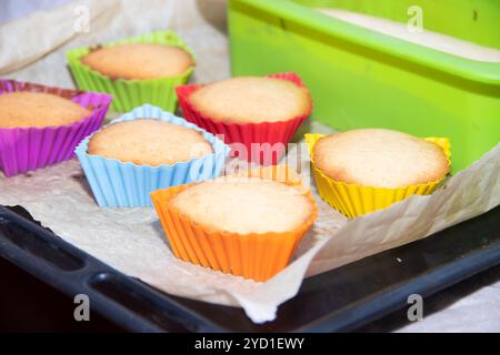 Muffin fatti in casa al silicone su pergamena. Cottura fatta in casa. Cupcake con una spugna. Foto Stock