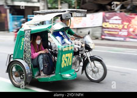 Manila-13 gennaio 2023: Taxi per moto con un piccolo sidecar in metallo coperto e angusti per i passeggeri. Una popolare forma economica di trasporto cittadino comunque. Foto Stock