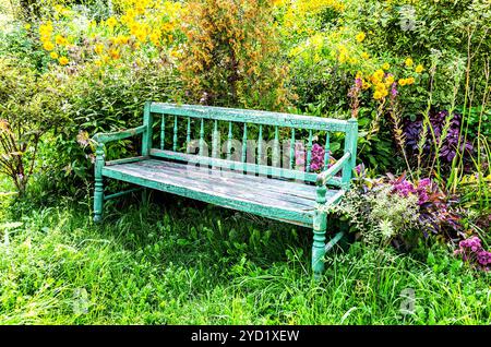 Vecchia panchina di legno nel giardino dei fiori Foto Stock