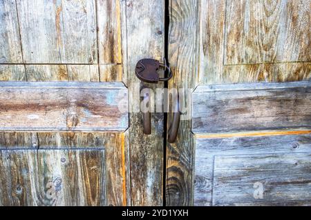 Vecchio cancello in legno con lucchetto arrugginito Foto Stock