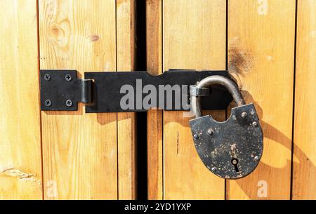 Massiccio cancello in legno con lucchetto Foto Stock