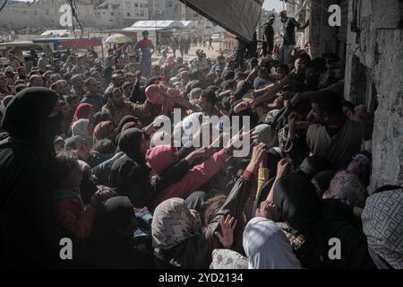 Pechino, Cina. 23 ottobre 2024. I palestinesi aspettano di comprare il pane dall'unica panetteria operativa nella città meridionale della Striscia di Gaza di Khan Younis, 23 ottobre 2024. Circa 1,84 milioni di persone in tutta la Striscia di Gaza stanno vivendo alti livelli di grave insicurezza alimentare, tra cui quasi 133.000 persone che devono affrontare una catastrofica insicurezza alimentare, secondo un recente rapporto pubblicato dal programma alimentare mondiale e dall'Organizzazione per l'alimentazione e l'agricoltura. Crediti: Rizek Abdeljawad/Xinhua/Alamy Live News Foto Stock