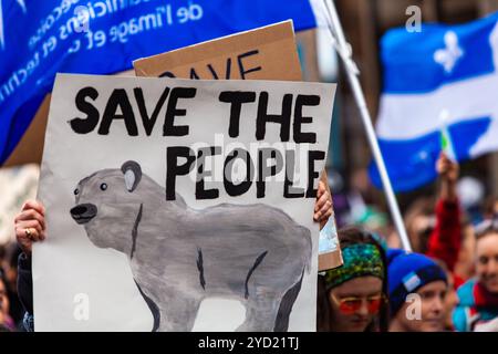 Una vista ingrandita di un segno detenute da un dimostrante durante una protesta ecologica rappresenta un sottopeso di orso polare e dice salva il popolo. Foto Stock