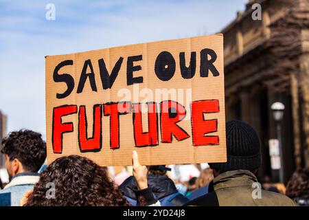 Una vista ravvicinata di una targhetta artigianale, la lettura di salvare il nostro futuro, come attivisti ambientali fase una protesta pacifica nel centro della citta'. Foto Stock