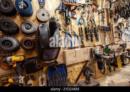 Gli utensili per la lavorazione dei metalli sono appesi alla parete in officina Foto Stock