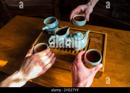 Girato durante un gong fu cha la cerimonia del tè con una piccola teiera su una barca di tè, posto su una tavola di legno Foto Stock