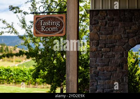 Sala di degustazione classico in legno segno di messa a fuoco selettiva, accanto a un muro di mattoni con vigneti in background, casa vigna, Okanagan Valley, Canada Foto Stock