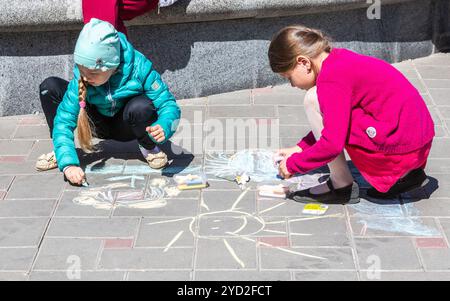 Samara, Russia - 25 Maggio 2019: giovani ragazze disegna su un marciapiede con gesso di colore. Al di fuori delle attività per i bambini in estate Foto Stock