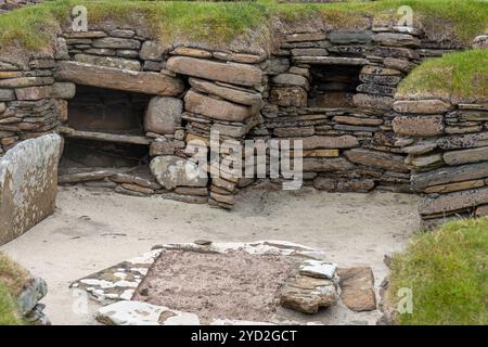 Vista ravvicinata di un'antica dimora a Skara Brae, un villaggio neolitico risalente a 5.000 anni fa conservato sull'isola continentale delle Orcadi in Scozia Foto Stock