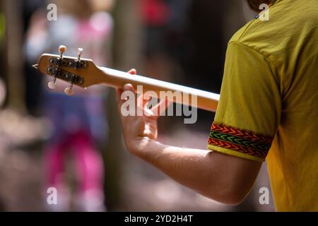 Uomo in maglia gialla che gioca a merlino Foto Stock