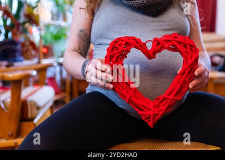 Donna incinta e cuore rosso di san valentino Foto Stock